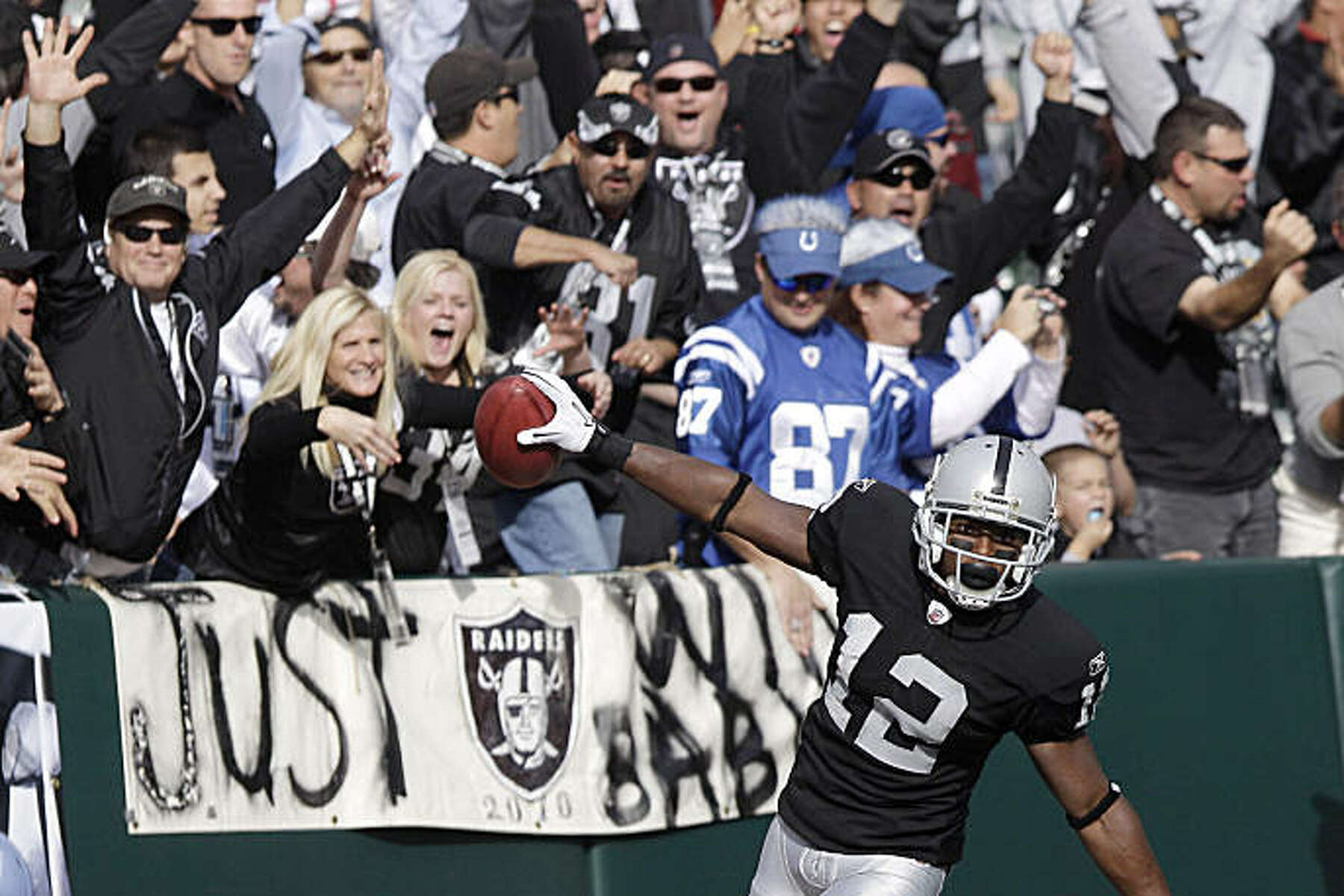 Oakland Raiders wide receiver Jacoby Ford (12) runs past the Indianapolis  Colts coverage team to score a touchdown on a 99-yard kickoff return in the  first quarter of an NFL football game