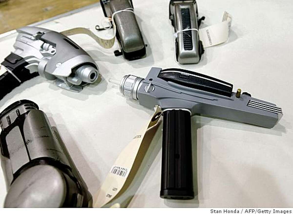 New York, UNITED STATES: Handheld energy weapons called "phasers" from the Star Trek series, including a replica of a phaser from the original television show (R), are displayed 08 August 2006 during a preview at a warehouse in the Bronx borough of New York. In celebration of the serie's 40th anniversary, Christie's will auction over 4,000 items from the CBS Paramount Television archives of the Star Trek television shows and movies on 05-07 October in New York. AFP PHOTO/Stan HONDA (Photo credit should read STAN HONDA/AFP/Getty Images)