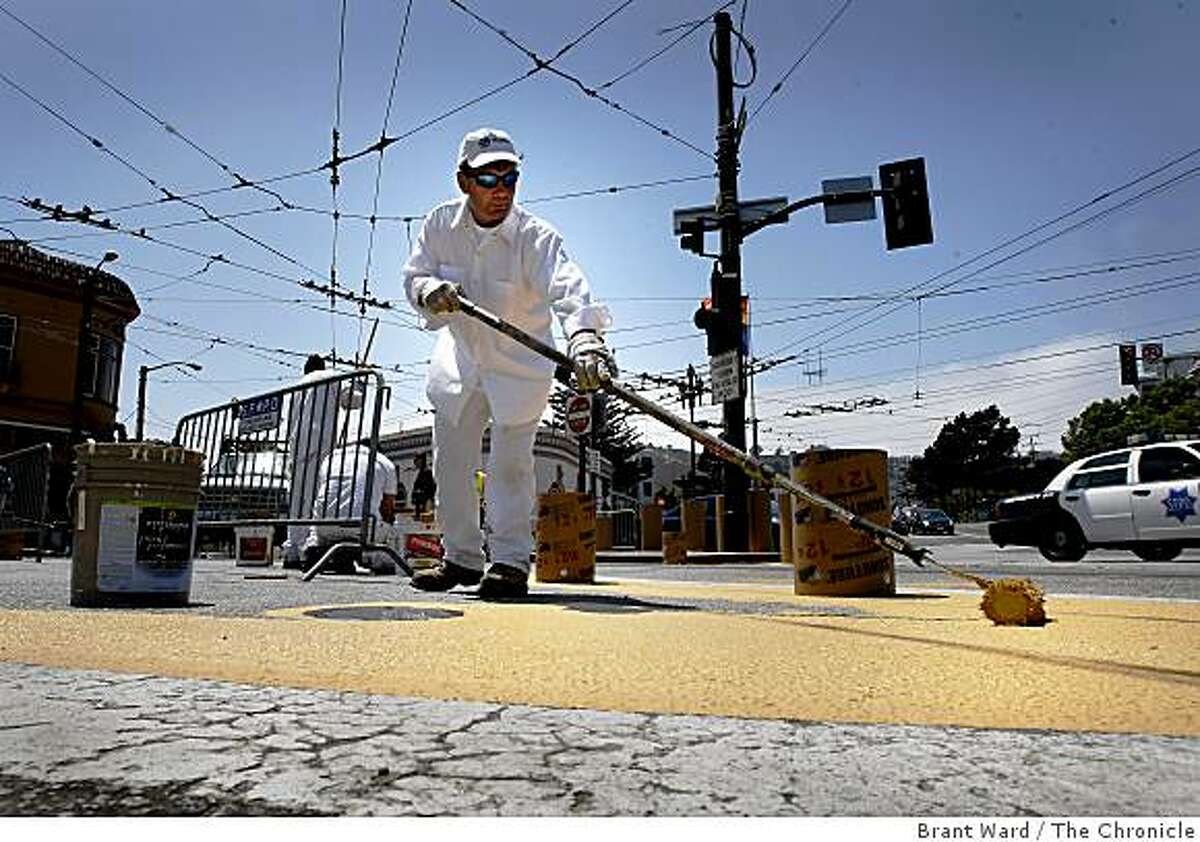 Pat O'Gorman with the Dept of Public Works, spread yellow paint in the intersection which will be closed to traffic soon. A small stretch of 17th Street near Castro will be turned into a trial pedestrian plaza, and a no-car zone.