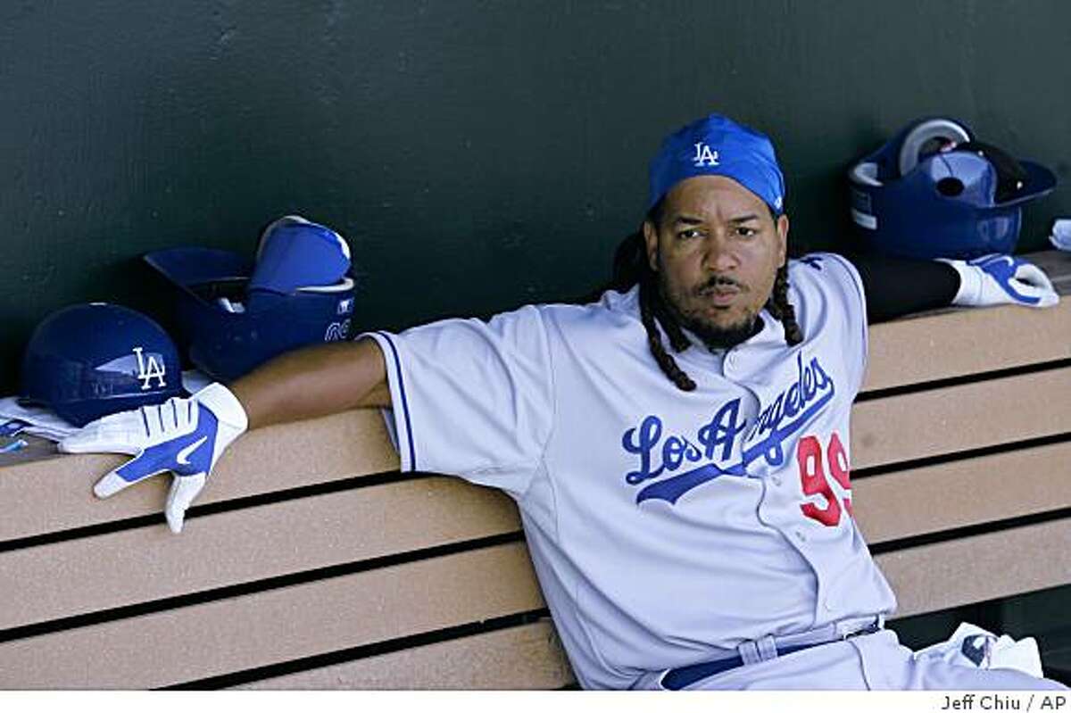 FILE - In this March 23, 2009 file photo, Los Angeles Dodgers' Manny Ramirez sits in the dugout against the Los Angeles Angels in a spring training baseball game in Tempe, Ariz. Ramirez has been suspended for 50 games by Major League Baseball, becoming by far the highest-profile player ensnared in the sport's drug scandals. (AP Photo/Jeff Chiu, File)