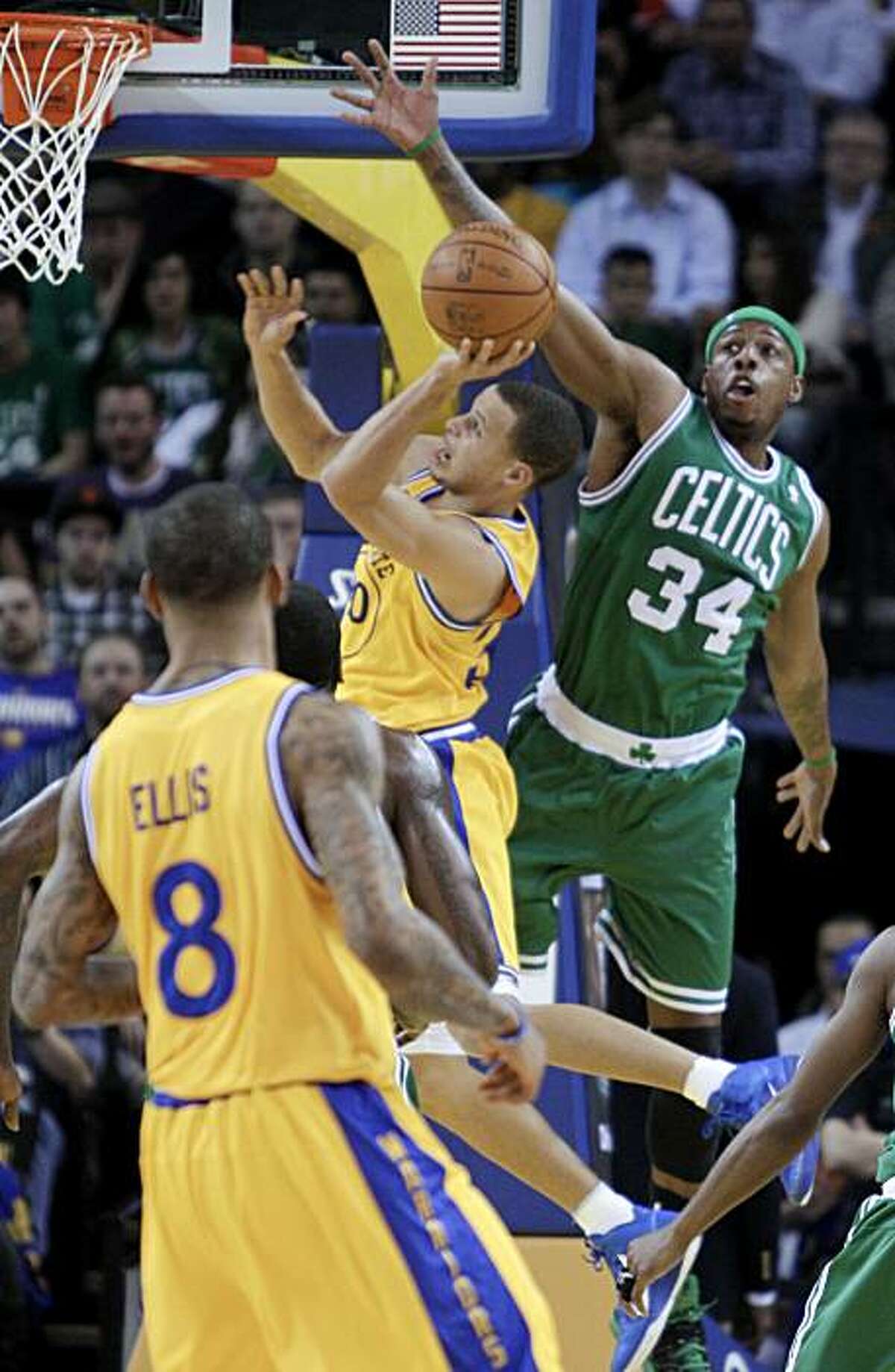 Boston Celtics' Paul Pierce (34) attempts to block the shot of Golden State Warriors' Stephen Curry during the first half of an NBA basketball game Tuesday, Feb. 22, 2011, in Oakland, Calif.