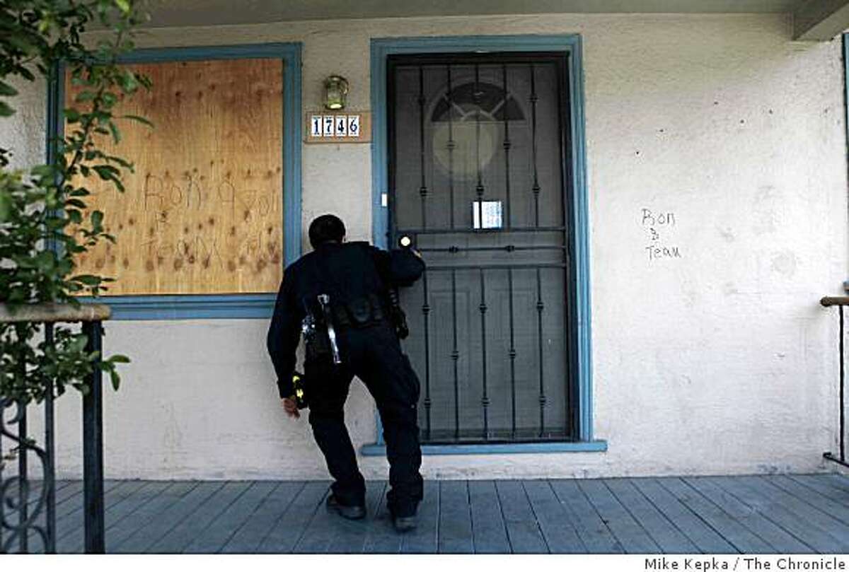 Oakland Problem Solving Police Officer, Mark Castillo, check on the status of a foreclosed home on 96th Avenue on Thursday April 30, 2009 in Oakland, Calif. Later he found a squatter living in the garage.