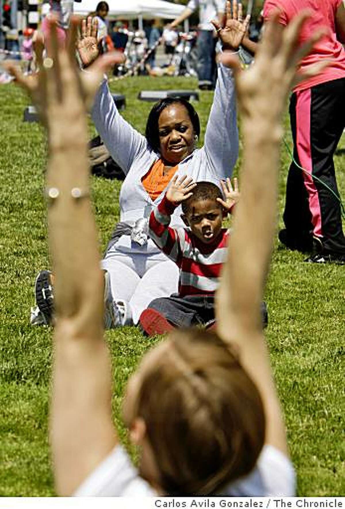 Clara McDaniel takes a Yoga class for kids with her grandson, Darnell Lemon, 4, on the Embarcadero on Sunday, April 26, 2009, that was part of the first Sunday Streets event for 2009. The event shut down the Embarcadero from about 9 a.m. to 1 p.m. from the ballpark to Fishermans' Wharf in San Francisco, Calif.