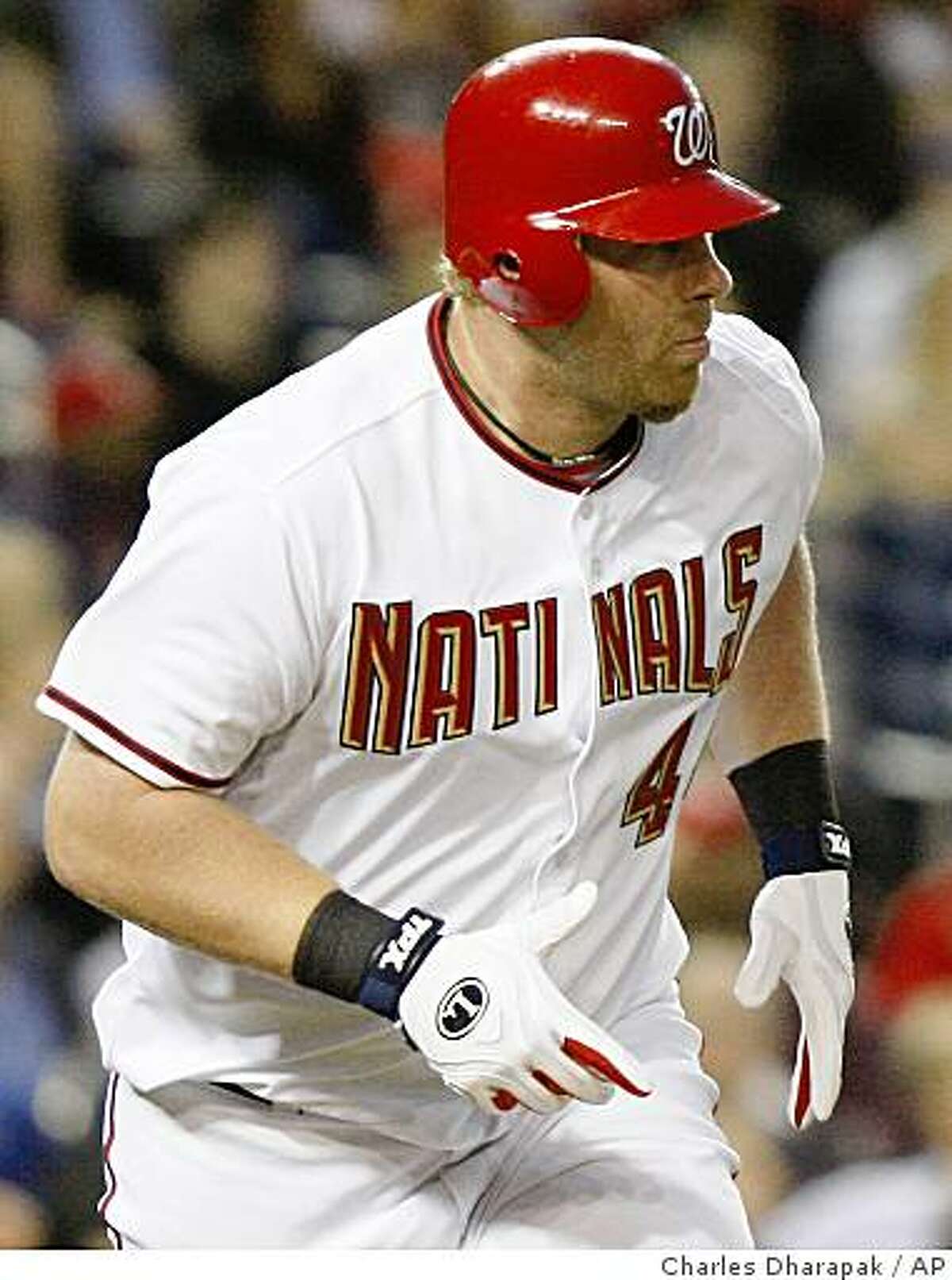 Washington Nationals' Adam Dunn is wearing a jersey spelled "Natinals" as he flies out to center field during the third inning of a baseball game against the Florida Marlins in Washington, Friday, April 17, 2009. The Marlins won 3-2. (AP Photo/Charles Dharapak)
