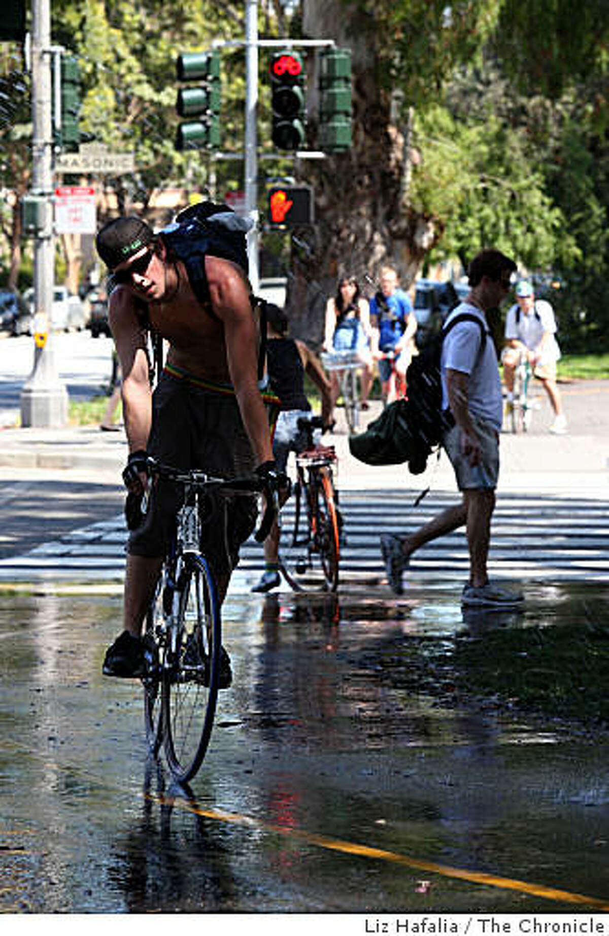 Cyclists going through water sprinklers on Fell at Masonic streets in San Francisco, Calif., on Friday, April 17, 2009.