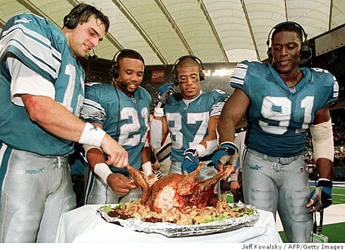 PONTIAC, : Detroit Lions from left Gus Frerotte (L), Greg Hill, Johnnie Morton and Robert Porcher get to sample FOX TV's Jon Madden's surgically altered turkey after their game against the Chicago Bears 25 November 1999 in Pontiac, Michigan. The Lions beat the Bears 21-17. AFP PHOTO/Jeff KOWALSKY (Photo credit should read JEFF KOWALSKY/AFP/Getty Images)