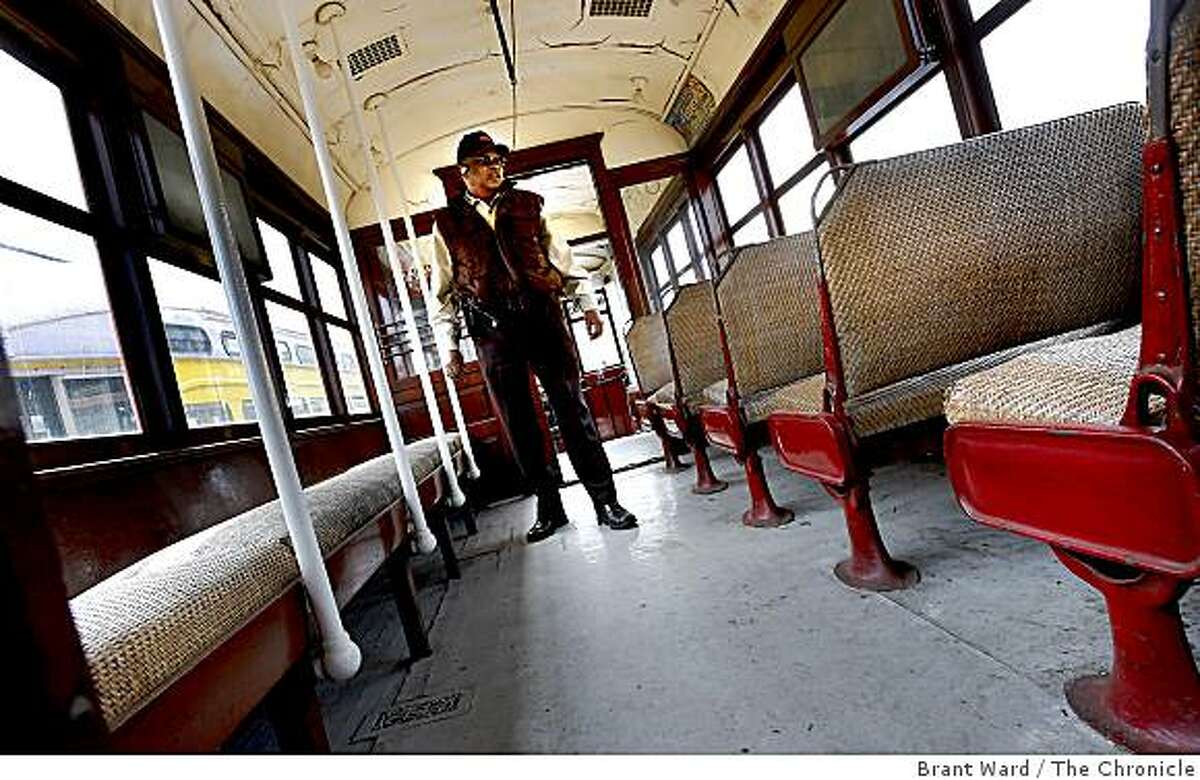 Gene Martin, who used to drive the old No. 1, walks through the passenger area with rattan covered seats. San Francisco's first publicly owned streetcar, which made its maiden run 97 years ago, will be restored at a cost of $1.8 million in time for MUNI's centennial celebration.