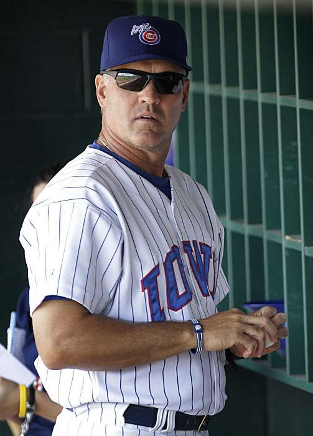 FILE - In this July 20, 2010, file photo, Iowa Cubs manager Ryne Sandberg stands in the dugout before his baseball team's game against the Oklahoma City Redhawks in Des Moines, Iowa. The Philadelphia Phillies have hired Sandberg to manager their Triple-Aaffiliate, the Lehigh Valley IronPigs.