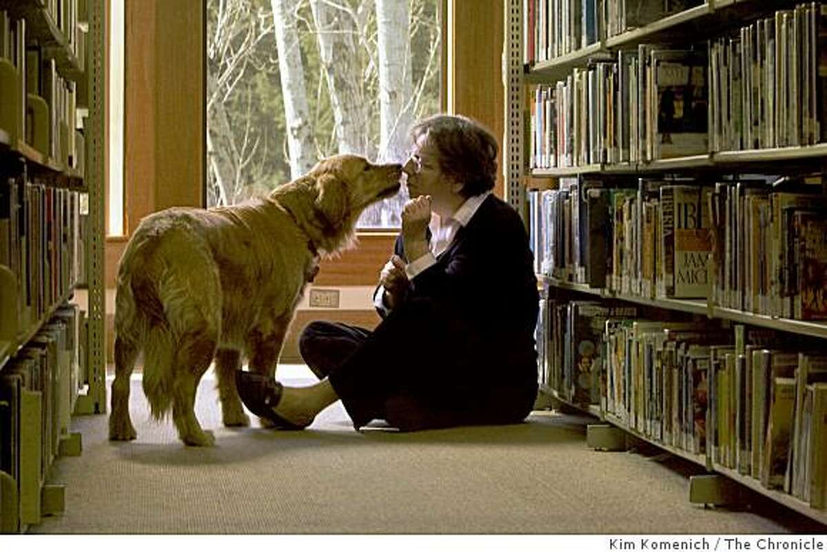 Research librarian Theresa McGovern and her dog Olivia play in the Fairfax, Calif., Library on Friday, Mar. 6, 2009. McGovern helped author Joe Gores research details about San Francisco in the 1920's to include in his book "Spade and Archer", the prequel to "The Maltese Falcon."