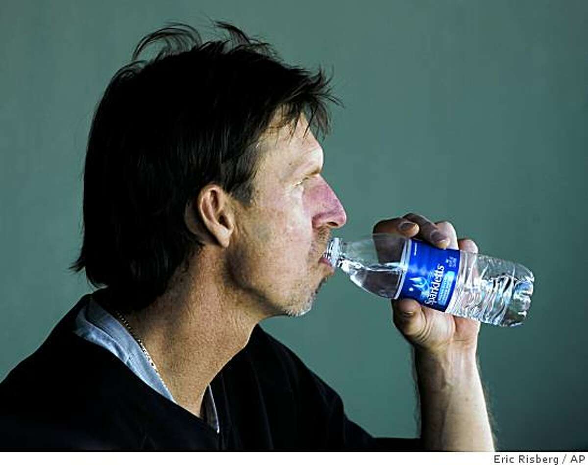 San Francisco Giants starting pitcher Randy Johnson takes a drink of water in the dugout after throwing against the Kansas City Royals in the first inning of their spring training baseball game in Scottsdale, Ariz., Friday, Feb. 27, 2009.