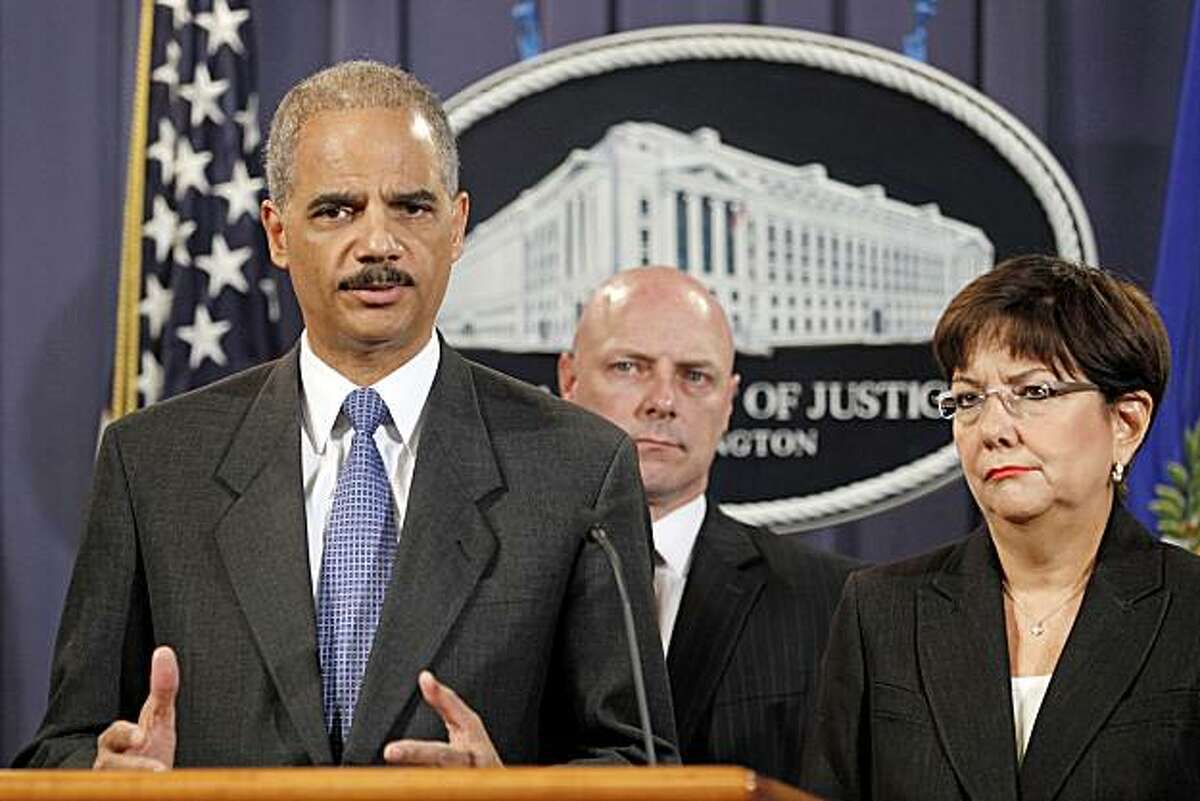 Attorney General Eric Holder, left, accompanied by US Attorney Rosa Emilia Rodriguez-Velez of the District of Puerto Rico, right, and FBI Executive Director Shawn Henry, answers questions during a news conference at the Justice Department in Washington, Wednesday, Oct. 6, 2010.