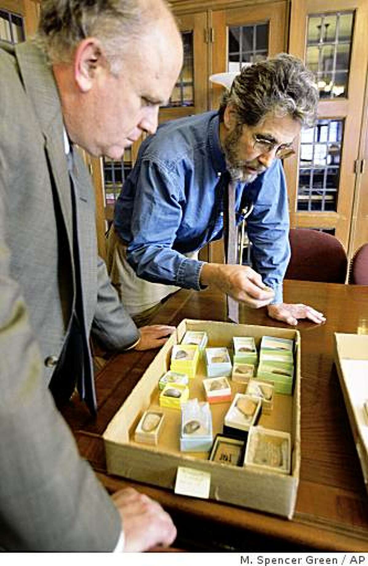 **ADVANCE FOR SUNDAY, FEB. 22** Gil Stein, director of the University of Chicago's Oriental Institute, left, and Matt Stolper, director of the Persepolis Fortification Archive, look over a selection of Aramaic tablets Oct. 16, 2008. The tablets are the subject of an unusual lawsuit. Victims of a terrorist bombing in Israel in 1997 won a multimillion judgment against Iran and are now trying to collect by seizing the tablets and selling them. (AP Photo/M. Spencer Green)