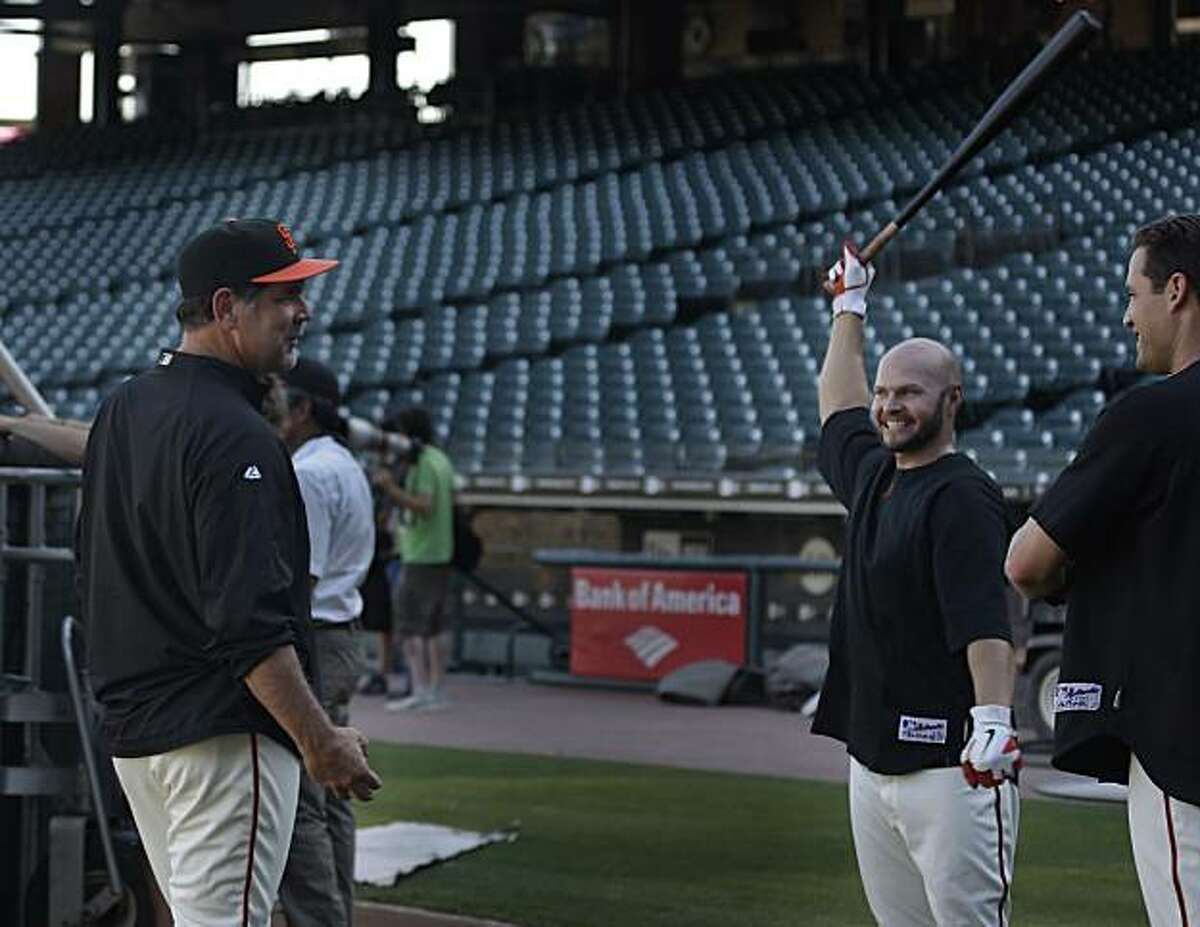 The San Francisco Giants manager Bruce Bochy (l to r) talks with right fielder Cody Ross and left fielder Pat Burrell during the Giants' workout at AT&T Park on Wednesday, October 13, 2010 in San Francisco, Calif.