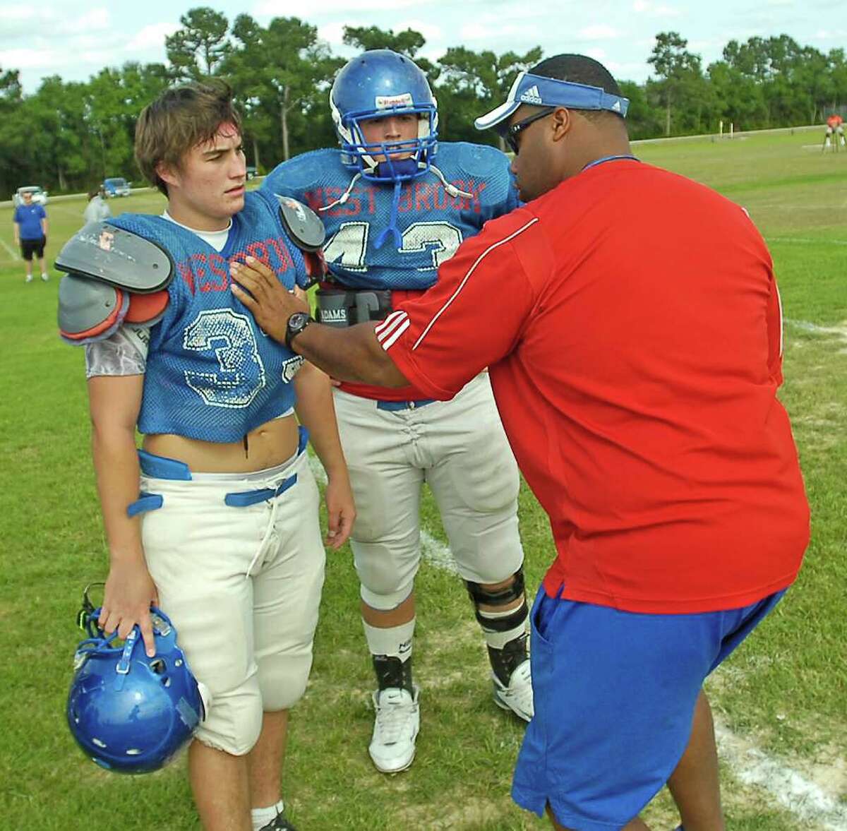 Spring football practice was held at the West Brook High School practice field Wednesday afternoon. The team practiced many running plays. Coach Joe Bowser, right, Offensive Line Coach, gives some pointers to two of his players after a drill that he did not like. Dave Ryan/The Enterprise