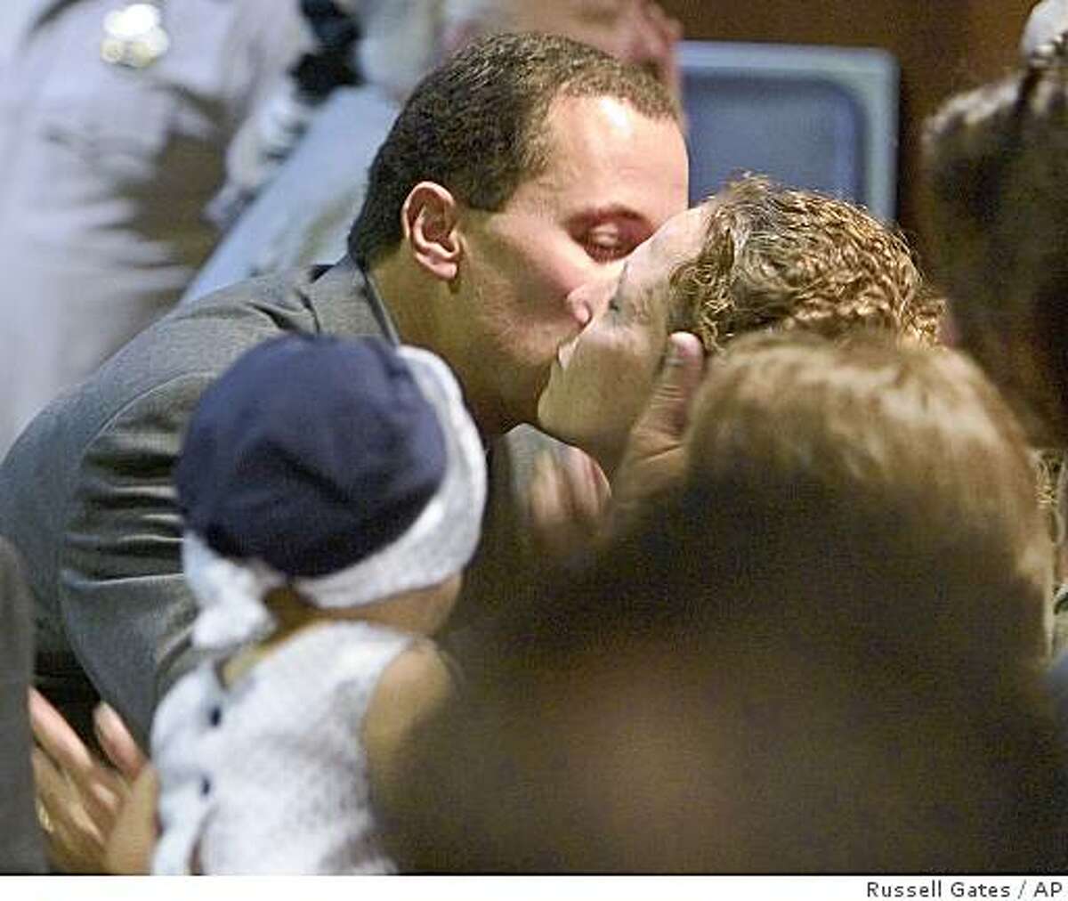 Former Chandler police Officer Dan Lovelace turns around and kisses his wife, Trish Lovelace, after he was acquitted Friday, July 9, 2004, in Mesa, Ariz., of second-degree murder and endangerment charges in shooting death of an Ahwatukee woman. (AP Photo/Pool, Russell Gates)