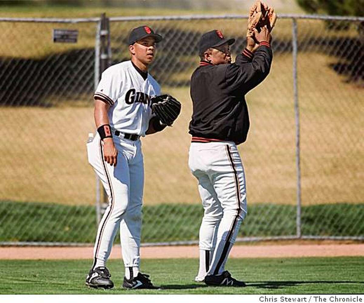 Baseball Spring Training: Former SF Giants outfielder Willie Mays (R) offers some ball catching pointers to current outfielder Darren Lewis.