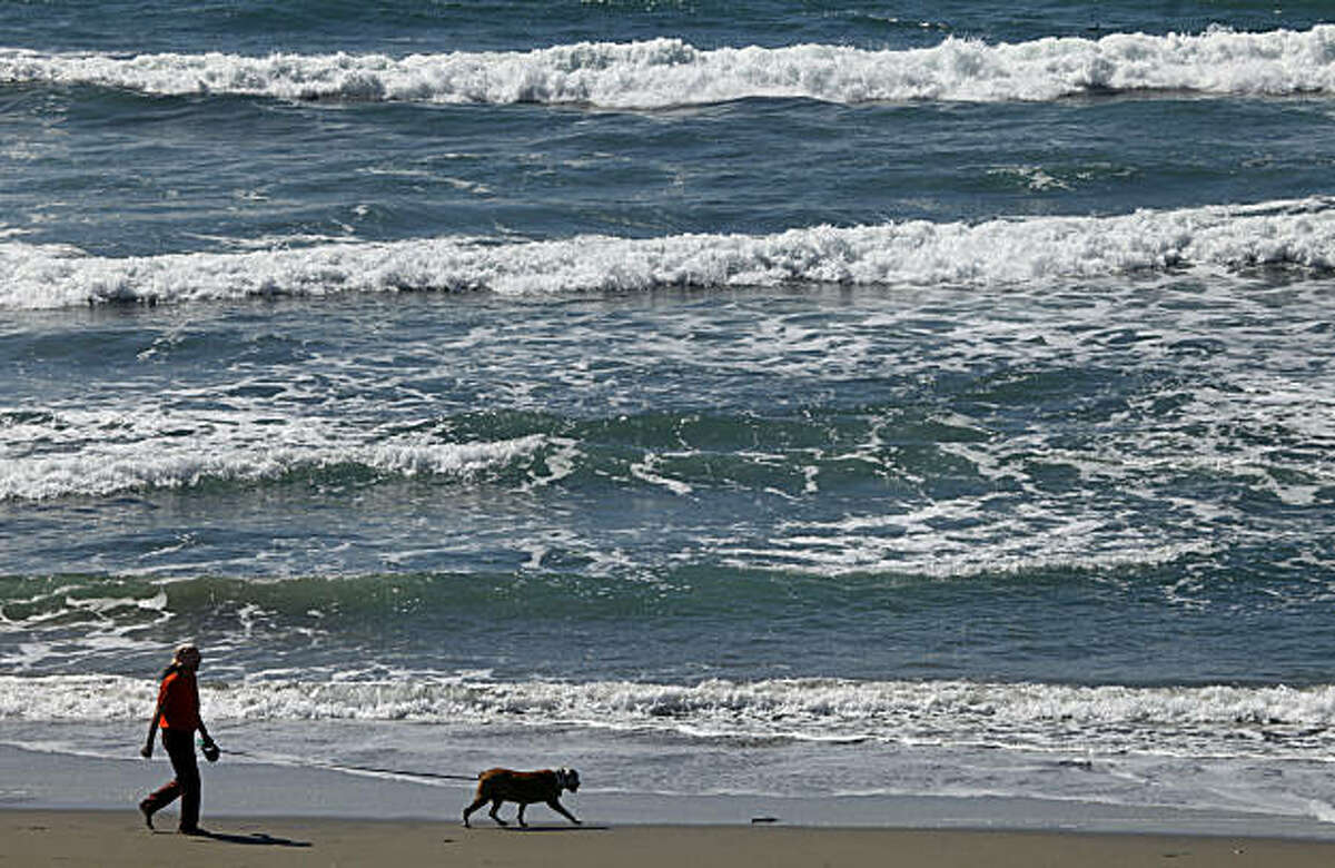 Alone on San Francisco's Ocean Beach a man walks his best friend Wednesday, Sept. 22, 2010. Temperatures are expected to climb as a high-pressure system moves into Northern California, inland highs are expected to reach the mid- 90's through the weekend. Wednesday, Sept. 22, 2010.
