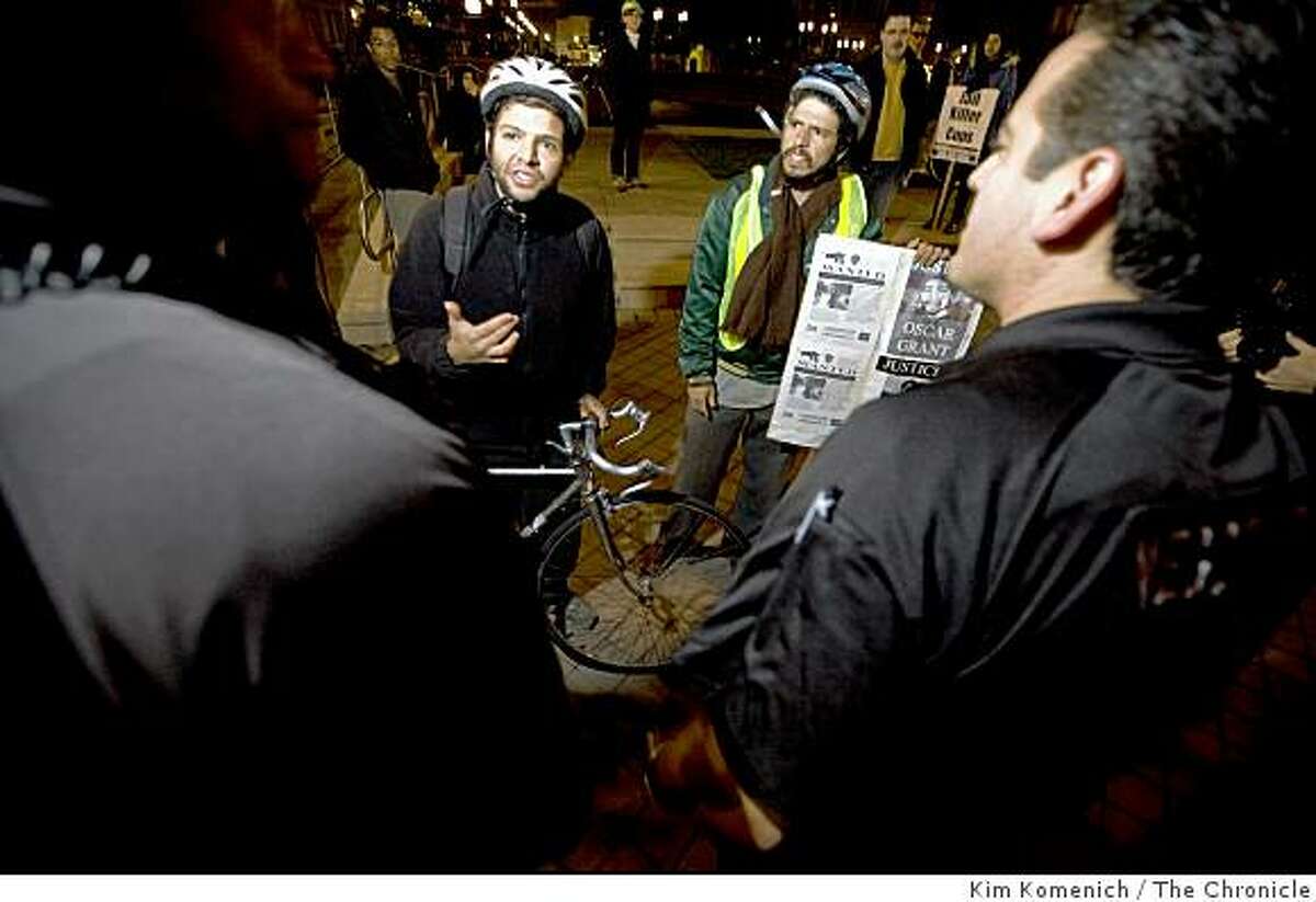 Two protesters identifying themselves as Josh (left) and Max (right) talk with Oakland Police officers as a crowd begins to gather in front of Oakland City Hall on Jan. 31, 2009, a day after former BART officer Johannes Mehserle was granted bail in the shooting death of Oscar Grant.