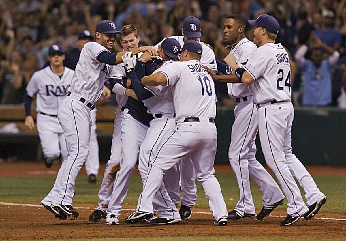 From left, Tampa Bay Rays' Sean Rodriguez, Reid Brignac, Kelly Shoppach (10), B.J. Upton and Dan Johnson (24) swarm Wily Aybar (obscured), center, as they celebrate a 4-3 win over the Los Angeles Angels during the 10th inning of a baseball game Saturday,Sept. 18, 2010, in St. Petersburg, Fla. Aybar knocked in the game-winning run of Angels reliever Bobby Cassevah.