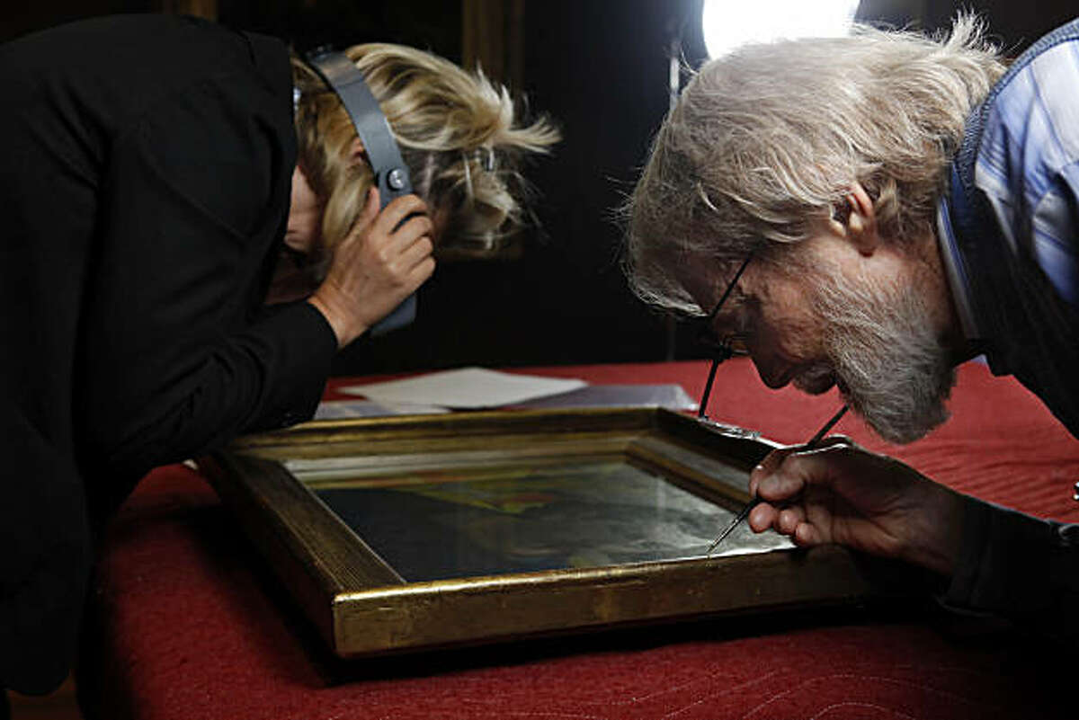 Tony Rockwell (right), paintings conservator, touches up the frame of Paul Gauguin's "The Artist with the Yellow Christ" while Laurence Madeline (left), curator for the MusŽe d'Orsay, examines the painting while they both conduct a conservation report at the De Young Museum in San Francisco, Calif. on Wednesday September 15, 2010.