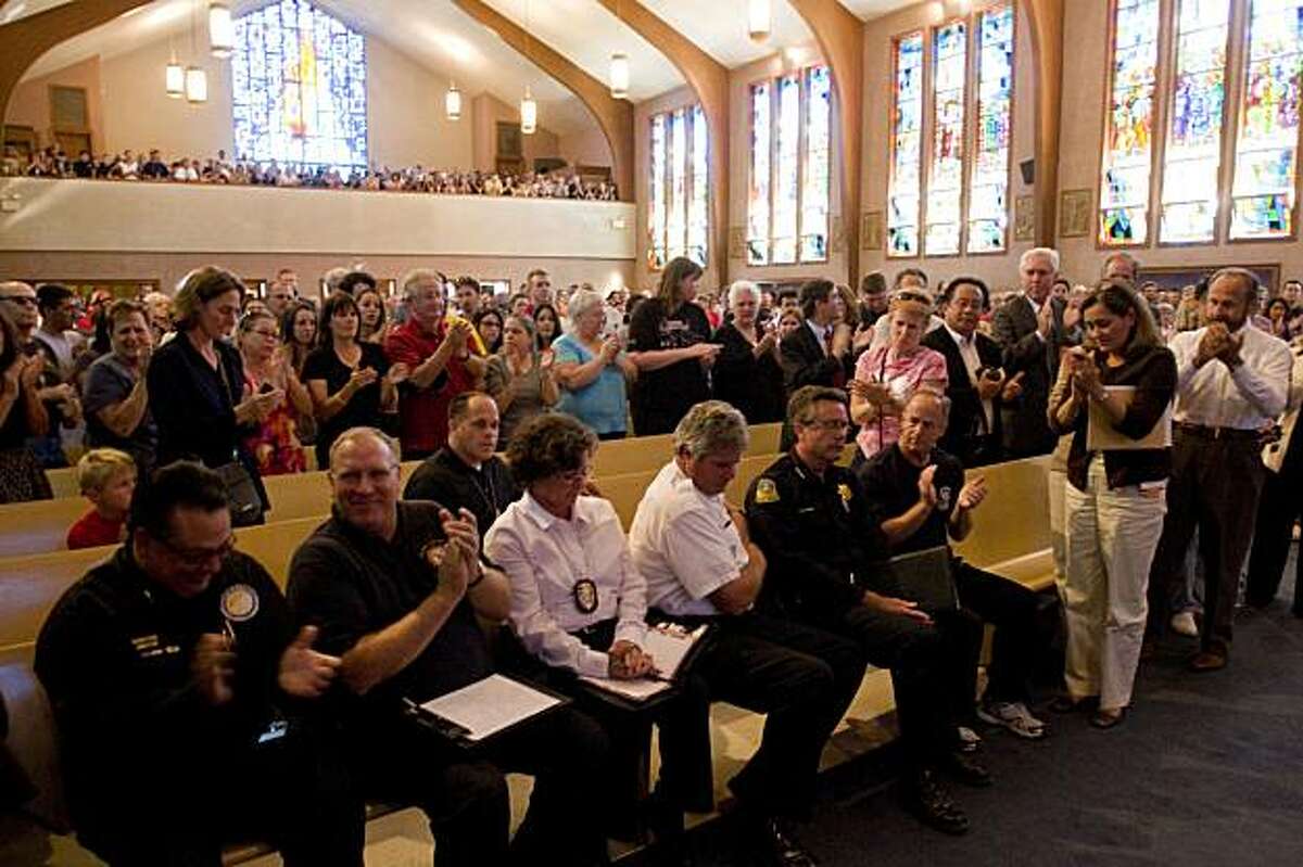 San Bruno police and fire services are given standing ovation by all in attendance in response to their efforts following the San Bruno explosion and fire during a town hall meeting held at St. Robert's Catholic Church on Saturday, September 11, 2010 to discuss the next steps to recovery after the devastating explosion and fire in San Bruno two days earlier.
