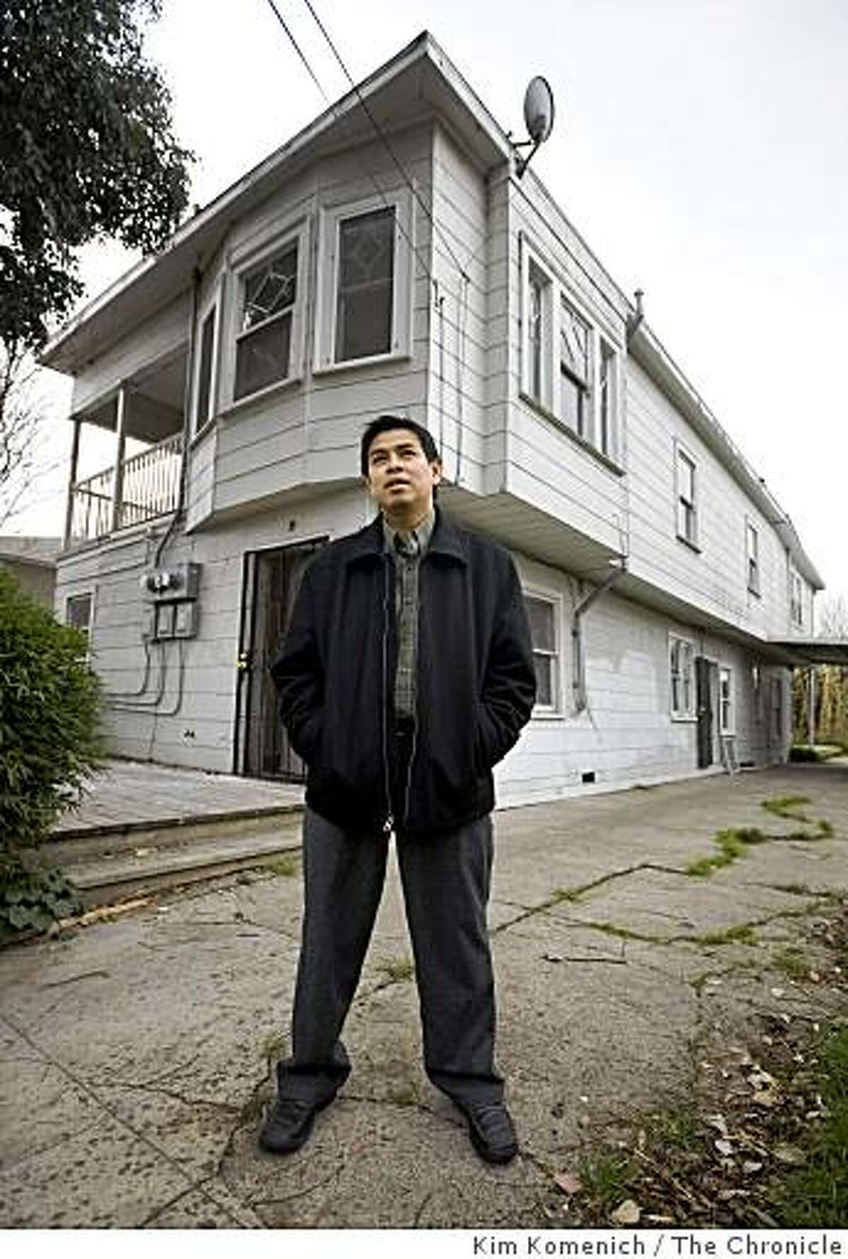 Real estate investor Chai Chanthapak stands outside the triplex he just bought in Oakland, Calif., on Tuesday, Jan. 20, 2009.