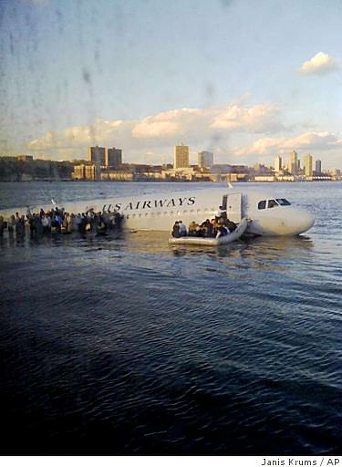 In this photo taken by a passenger on a ferry, airline passengers egress a US Airways Airbus 320 jetliner that safely ditched in the frigid waters of the Hudson River in New York, Thursday Jan. 15, 2009 after a flock of birds knocked out both its engines. All 155 people on board survived. (AP Photo/Janis Krums)