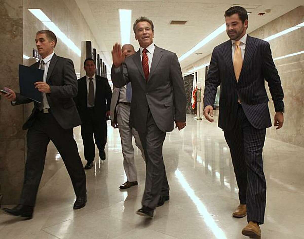 Gov. Arnold Schwarzenegger waves to well-wishers as he walks to a news conference at the Capitol in Sacramento, Calif., Wednesday, Sept. 1, 2010. Schwarzenegger refused to comment on GOP gubernatorial candidate Meg Whitman's comments blaming his lack ofleadership for the state's failure to pass a budget two months into the new fiscal year.