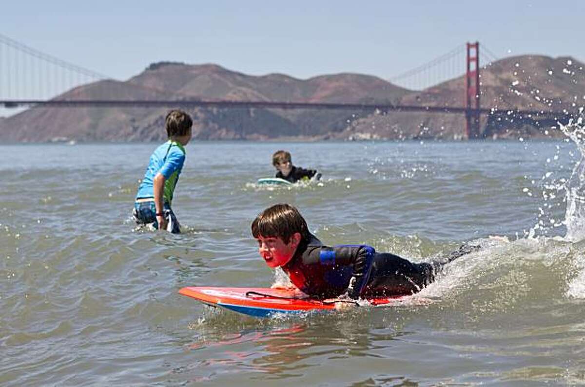 Radley Peschel, 12, catches a wave on his board while playing in the water at Crissy Field in San Francisco on Tuesday.
