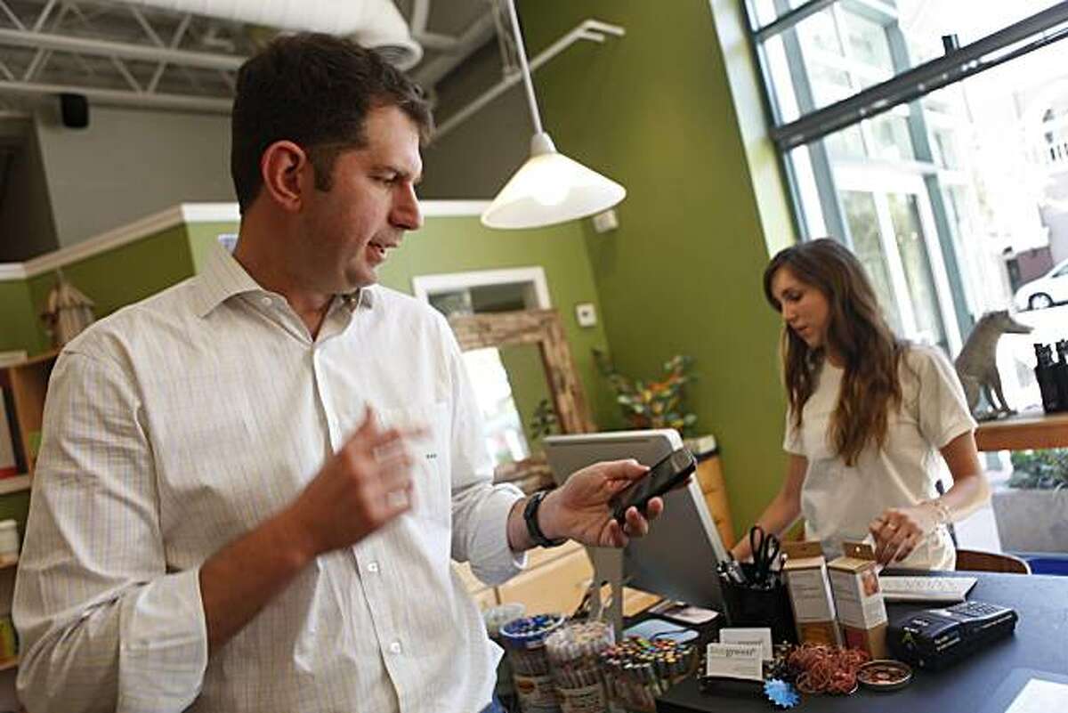 Bling Nation co-CEO Meyer Malek (left) who made his purchase with a Bling tag at Live Greene checks his phone for the receipt after payment in Palo Alto, Calif. on Wednesday August 18, 2010.
