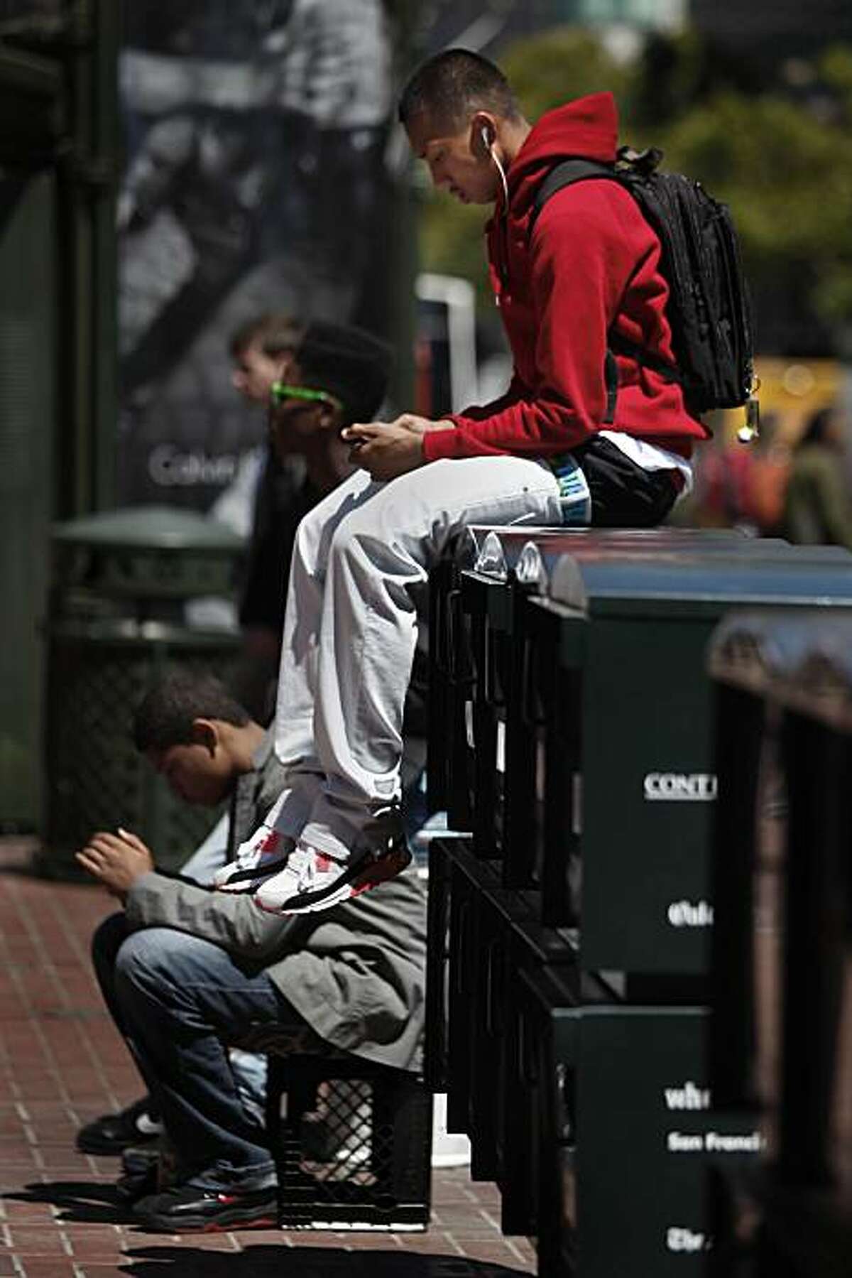 Christopher "Jtro" Navarro, 18, of San Francisco listens to music on his Ipod while sitting atop newspaper racks on Market Street in San Francisco, Calif. on Tuesday August 17, 2010.