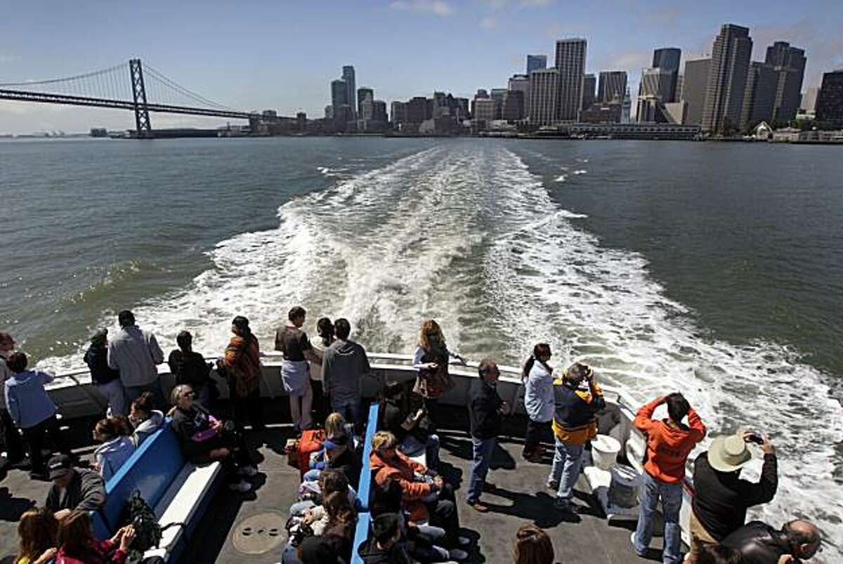 Passengers aboard the San Francisco ferry take photos of the city skyline from the fantail Friday August 13, 2010. The Golden Gate Ferry system will celebrate their 40th anniversary serving Fan Francisco, Larkspur and Sausalito this weekend.