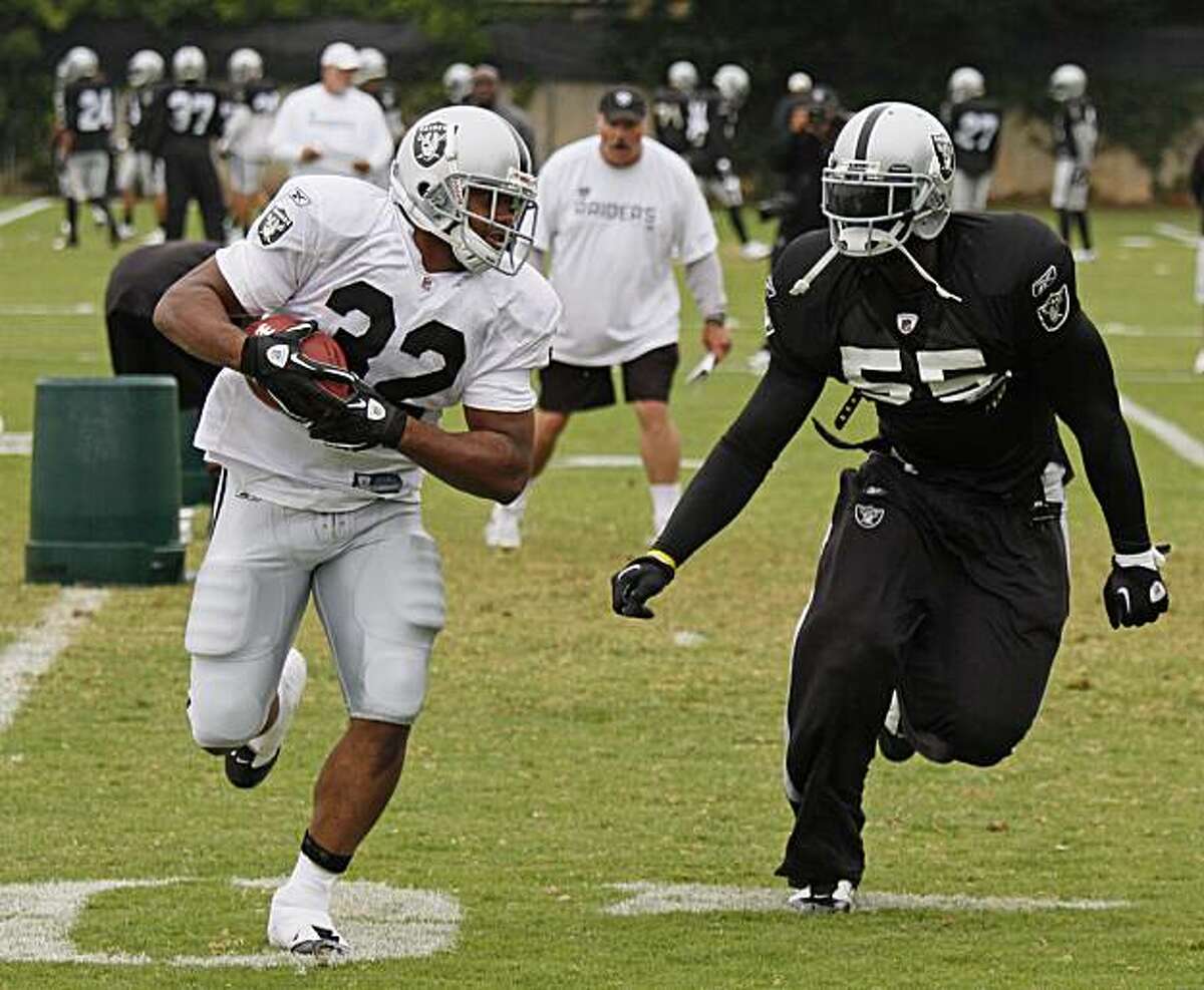 Oakland Raiders running back Michael Bennett, left, runs with the ball as linebacker Rolando McClain, right, defends during NFL football training camp in Napa, Calif., Tuesday, Aug. 3, 2010.