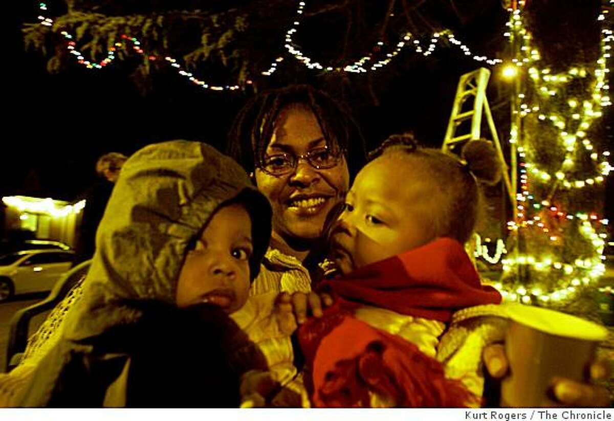 Towanda Gusters with her two kids Deontay one and Akeelah Two stayed warm as the Picardy drive lit their annual friendship Christmas tree and kicked off the holiday season with about twenty people on hand to watch. on Saturday Dec 13, 2008 in Oakland , Calif