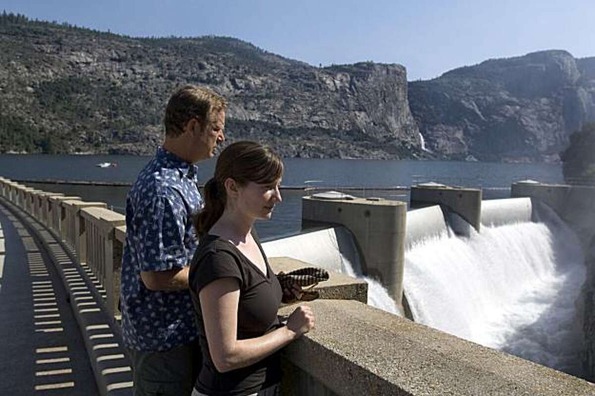 Environmental Defense analyst Spreck Rosekrans, left, and fellow analyst Ann H. Hayden look over O'Shaughnessy Dam, Monday, July 24, 2006, near Yosemite National Park, Calif. With its soaring granite cliffs and spouting waterfalls, Yosemite's Hetch Hetchy Valley was described by conservationist John Muir as "one of Nature's rarest and most precious mountain temples." But much of the valley now lies submerged under 300 feet of water, after it was dammed and flooded more than 80 years ago to supply drinking water and hydropower to the San Francisco Bay area. (AP Photo/Al Golub)