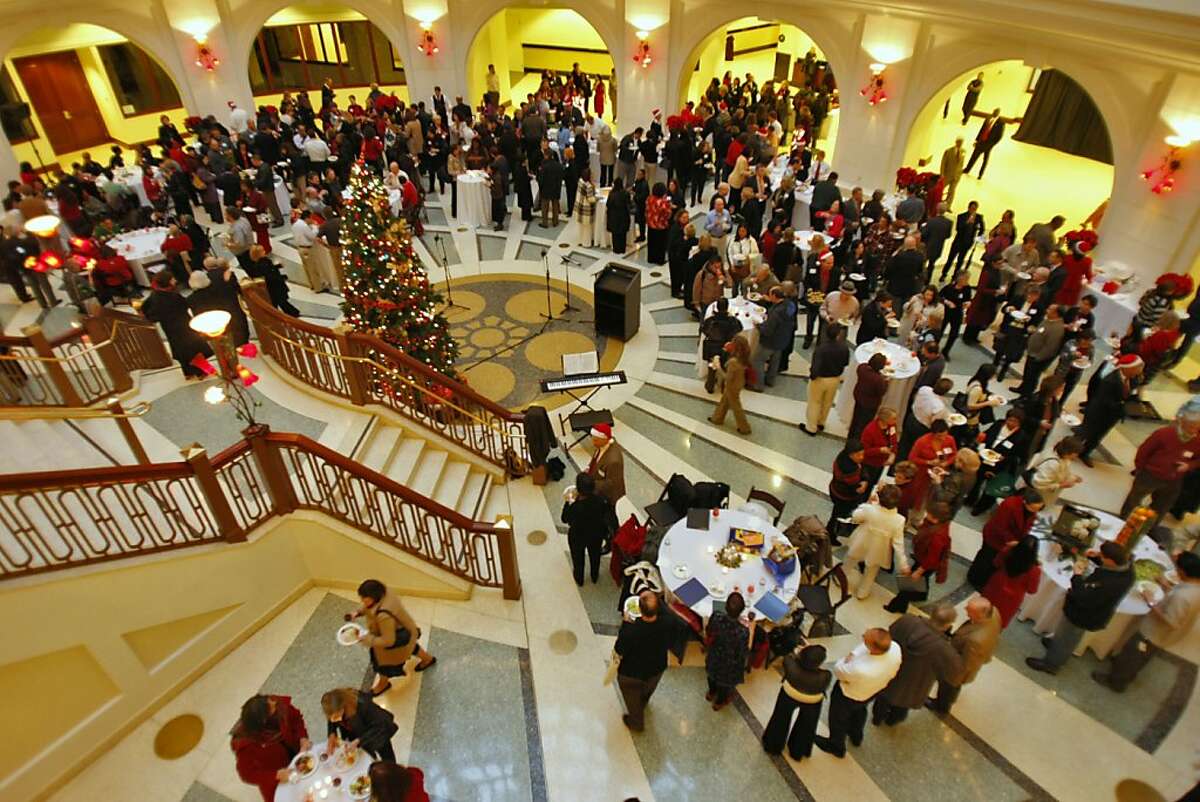 Hundreds of employees of the University of California's Office of the President celebrate the holidays at their annual Christmas Party in the lobby of the Rotunda Building, Monday Dec. 15, 2008, in Oakland, Calif.