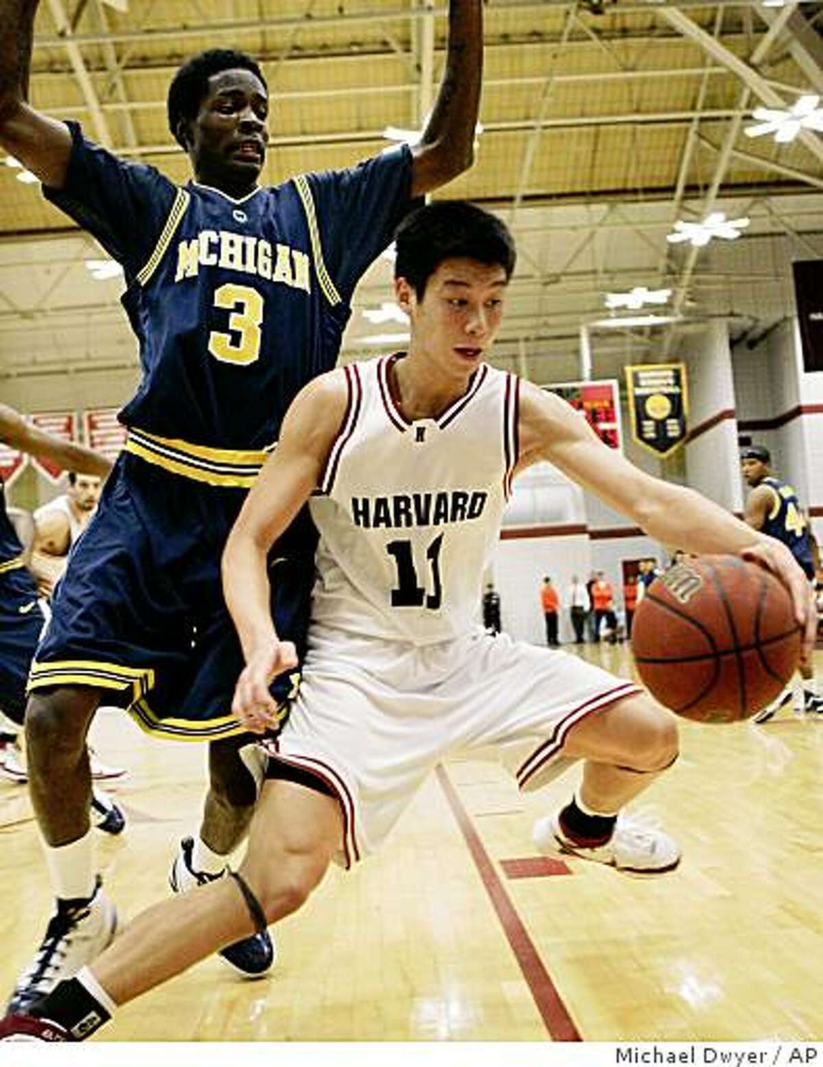 Harvard's Jeremy Lin (11) keeps the ball away from Michigan's Manny Harris (3) in the second half of a basketball game Saturday, Dec. 1, 2007, in Boston. Harvard won 62-51. (AP Photo/Michael Dwyer)