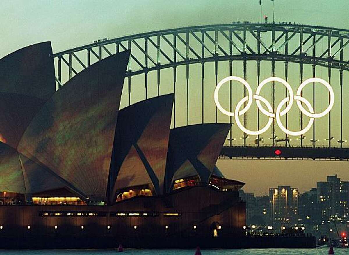 The famous Sydney Harbour Bridge with the Olympic rings and the Opera House with the Earth lighting projection are lit up in Sydney, Thursday, September 14, 2000. The opening of the 2000 Summer Games will start Friday in Sydney.