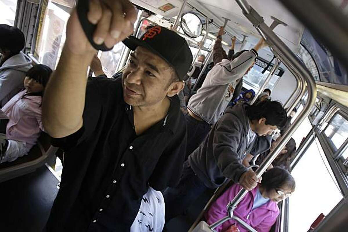 Orlando Cesna of San Francisco holds a hand strap while riding the 14L Muni line in San Francisco, Calif. on Tuesday July 6, 2010.
