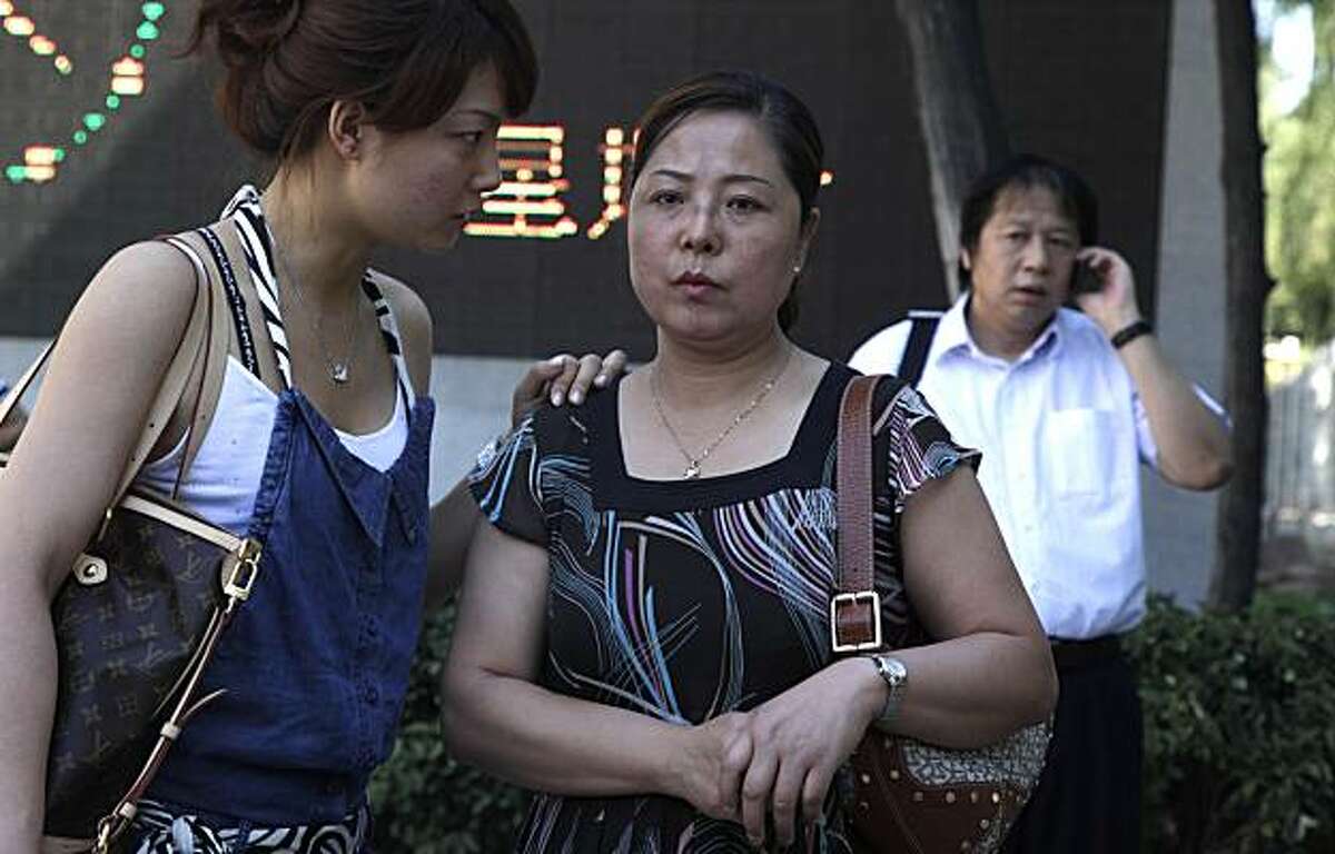 Xue Min, center, waits with her daughter Guo Jie for the trial of Xue's brother Xue Feng outside the Beijing No. 1 Intermediate People's Court where sentencing for Xue Feng was to take place in Beijing, China, Monday, July 5, 2010. Xue Feng, an Americangeologist detained and tortured by China's state security agents over an oil industry database, was jailed for eight years Monday in a troubling example of China's rough justice system and the way the U.S. government handles cases against its citizens. The court convicted Xue Feng of collecting intelligence for overseas and illegally providing state secrets. At right is Xue Feng's lawyer Tong Wei.
