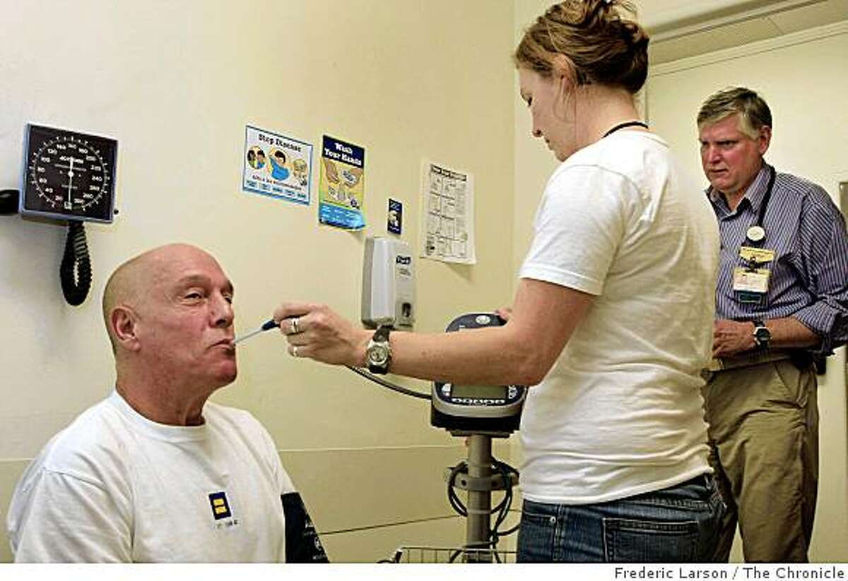 Richard Apodaca an AIDS out patient (sitting) gets a routine check up from Katie Carlson, a medical assistance, while Dr. Dan Wlodarczyk (far right) looks on at the AIDS ward at San Francisco General Hospital on November 25, 2008.
