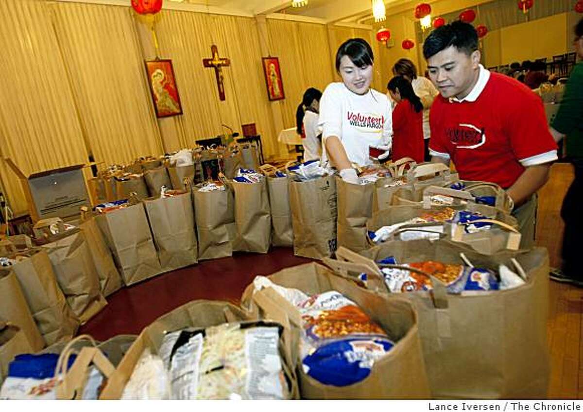 Employees of Wells Fargo Bank including Amy Wang and Eric Young donated their time to put 114 bags together for needy seniors living in the Western Edition. Each bag contains enough groceries to sustain one person for a week. Tuesday, Nov. 25, 2008.
