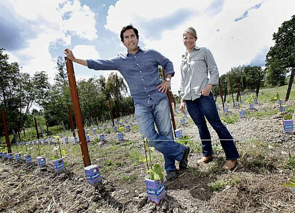Andy Erickson (left) and Annie Favia in their Sauvignon Blanc vineyard in front of their home Tuesday May 18, 2010. The little blue juice containers protect the young vines from local critters. Annie Favia and Andy Erickson are top viticulturists and winemakers in Napa, Calif. They live on the east side of Napa and have established their own wine, Favia.