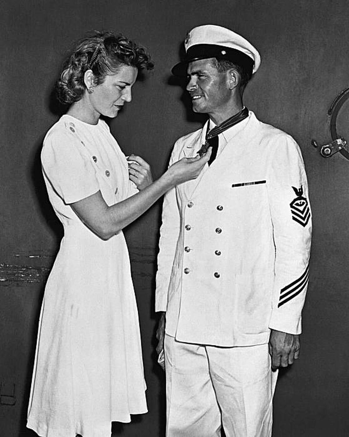 FILE - In this Sept. 28, 1942 photo provided by the U.S. Navy, Chief Ordnanceman John W. Finn is congratulated by his wife Alice at Pearl Harbor, Hawaii, after he was awarded the Congressional Medal of Honor or heroism at Kaneohe Naval Air Station for hisactions during the attack on Pearl Harbor. Finn, the oldest Medal of Honor recipient from World War II, died Thursday May 27, 2010 at his San Diego-area home at age 100.
