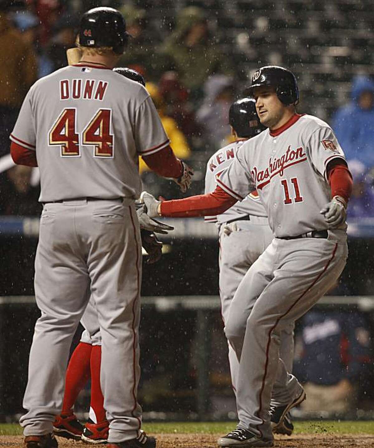 Washington Nationals' Adam Dunn, left, congratulates teammate Ryan Zimmerman as he crosses home plate after hitting a three-run home run against the Colorado Rockies in the fifth inning of a baseball game in Denver on Thursday, May 13, 2010.