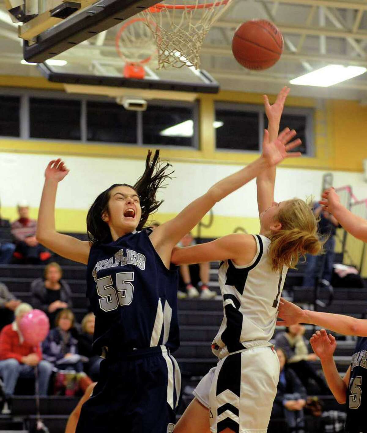 Staples' #55 Madeline Schemel, left, tries to block a shot by Trumbull's #1 Alexa Pfohl, during girls basketball action in Trumbull, Conn. on Friday February 10, 2012.