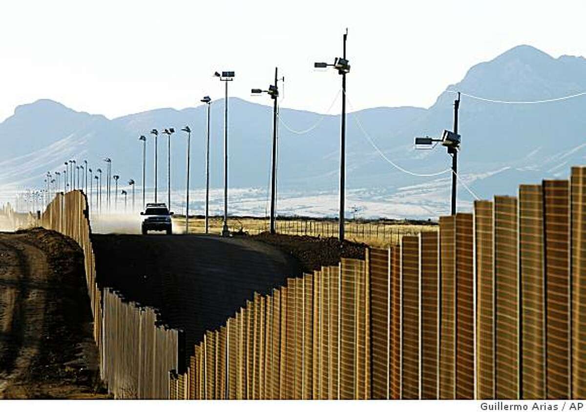 A U.S border patrol vehicle rides along the fence at the U.S-Mexican border near Naco, Mexico, Sunday, Jan. 13, 2008. (AP Photo/Guillermo Arias)