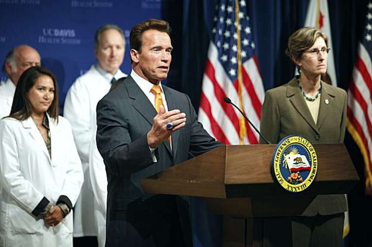Gov. Arnold Schwarzenegger, center, is joined by University of California Davis Medical Center staff members and Secretary of Health and Human Services Agency Kim Belshe, right, to pledge California's full support for national health care reform during anews conference in Sacramento, Calif. on Thursday, April 29, 2010.