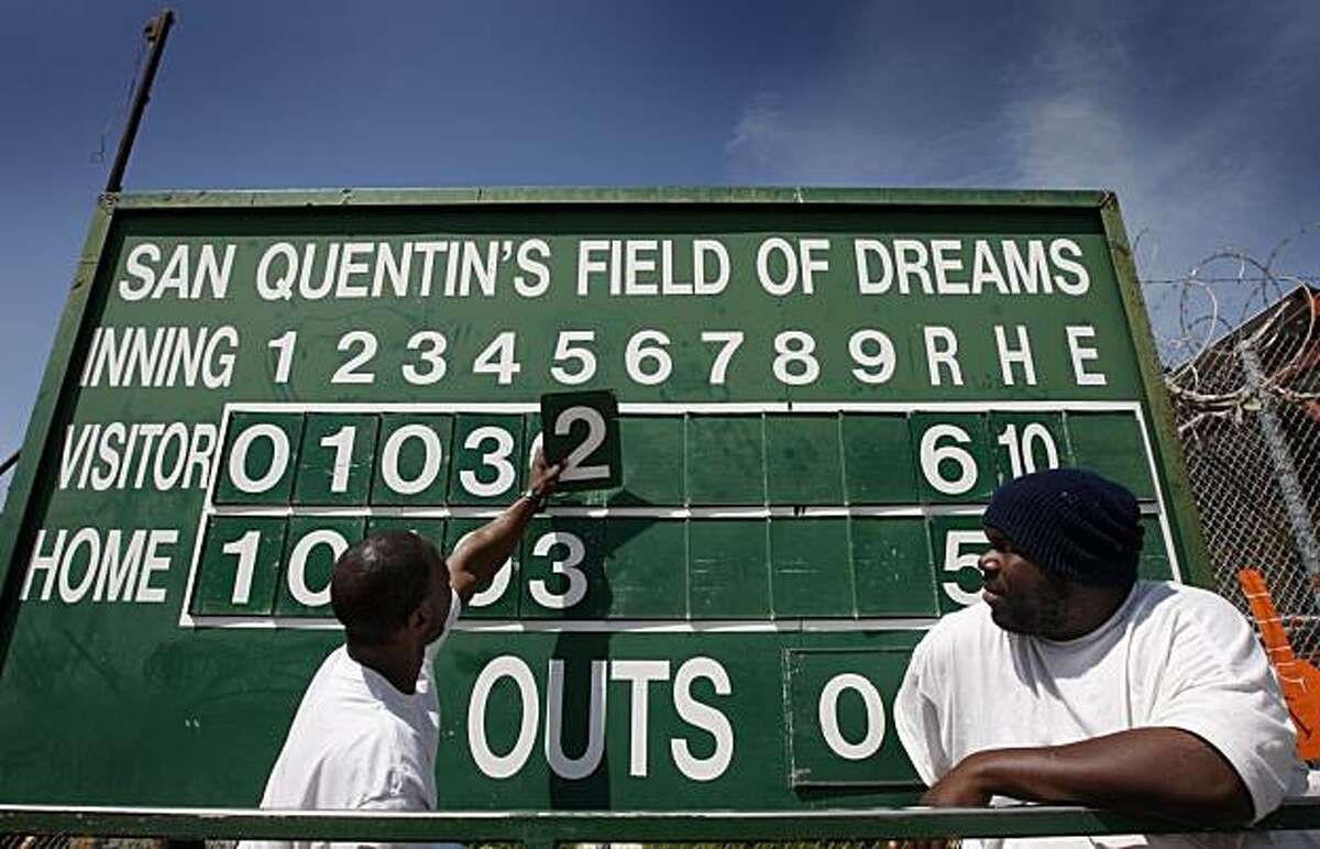 Inmates Dwight Kennedy (left) and Marcus Dishmon update the scoreboard during the Opening Day of baseball season for the San Quentin Giants in San Quentin on Saturday.