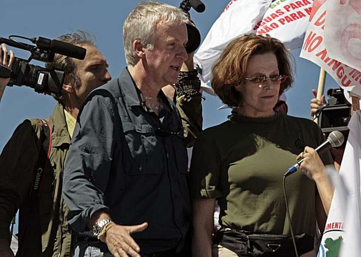 Director James Cameron, left, and actress Sigourney Weaver, right, march during a protest against a proposed dam in the Amazon in Brasilia Monday April 12, 2010. Brazil's government says the Belo Monte project will provide much-needed clean energy for the country. Indian groups say they will be displaced by the dam and environmentalists say its benefits won't make up for the damage to the jungle.
